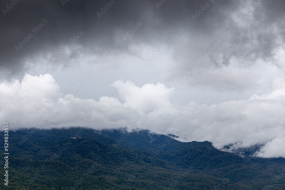 Mountain view in the morning with clouds floating in front after the rain.