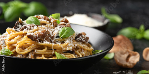 Porcini and woodland mushrooms pasta with pecorino cheese, basil in black bowl