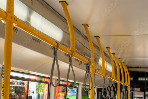 Handrails inside the bus or subway for safe passage of passengers. Modern safe public transport. The interior of an empty electric bus.