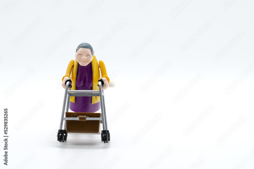 Grandmother with walker, toys, white background, cropped image Grandmother with walker, toys, white background, cropped image