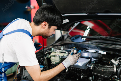 Car Service Center and Automobile Maintenance, Auto mechanic is diagnosing the cause of an engine problem that needs to be fixed at the shop © thanmano