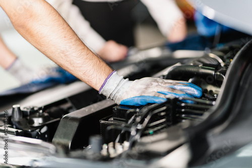 Close up of a technician operating and inspecting an engine while wearing gloves, Car Service and Automobile Maintenance Concept