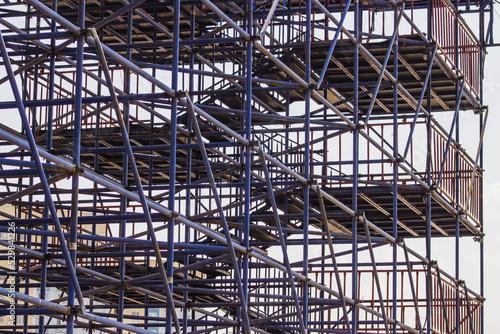 Extensive scaffolding providing platforms for work in progress in a new apartment building, high-rise building under construction with scaffolding