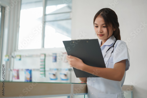 Medicine and health concept, Female pharmacist is writing prescription and medicinal properties