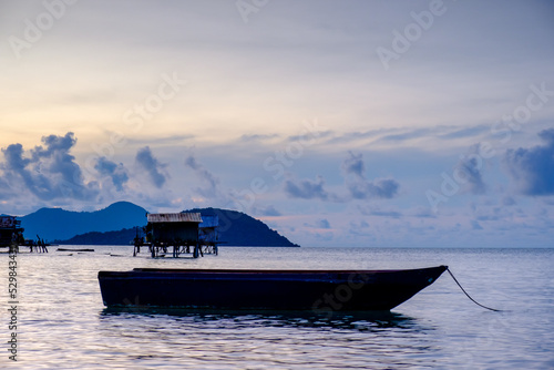 Soft image of beautiful hue of sunrise at Maiga Island with silhouette of seagypsy village located at Semporna, Sabah, Malaysia. Rarely seen sunrise at the island, especially the colour. photo