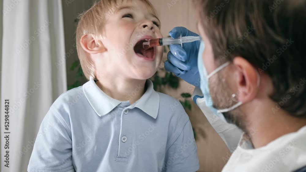 Kid getting polio drops. Doctor making to Child Oral Vaccination against infection. Little Blonde Hair Boy at Hospital. Children health care and disease prevention. Via of Polio Vaccine. Immunization. Kid getting polio drops. Doctor making to Child Oral Vaccination against infection. Little Blonde Hair Boy at Hospital. Children health care and disease prevention. Via of Polio Vaccine. Immunization.