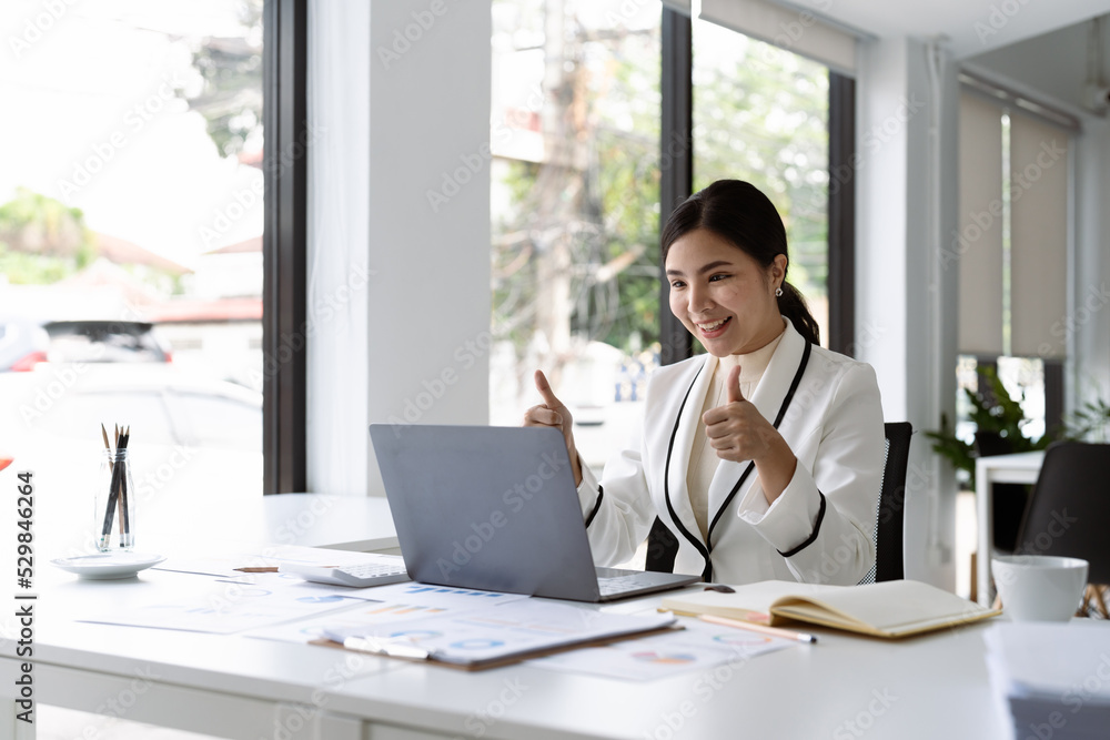 Asian business woman thumbs up to her colleagues about plan in video conference. Multiethnic business team using computer for a online meeting in video call. Asian business woman thumbs up to her colleagues about plan in video conference. Multiethnic business team using computer for a online meeting in video call.