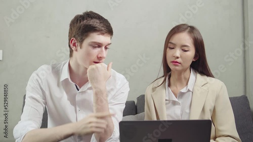 Young businessman and businesswoman meeting together with laptop, caucasian man in white shirt order to asian woman in suit