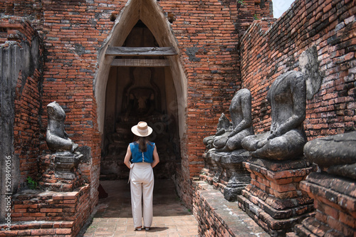 Young Asian women tourist traveling at Wat Chaiwatthanaram, ancient buddhist temple, famous and major tourist attraction religious of Phra Nakhon Si Ayutthaya, Thailand photo