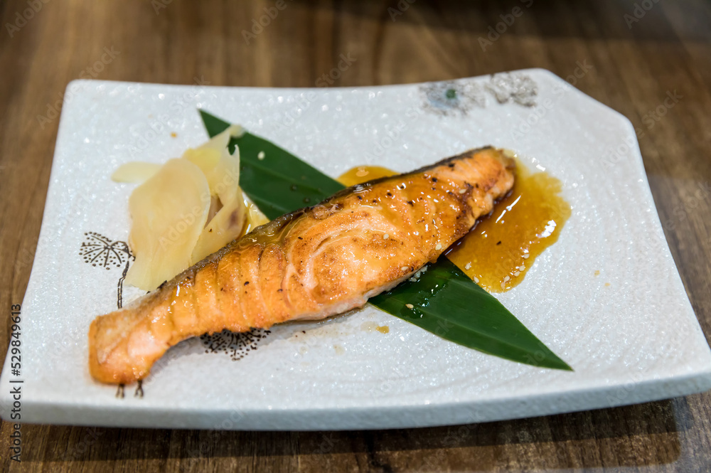 Grilled salmon on grill with slice ginger. Fried salmon steak. Japanese Salmon Grilled (Salmon Shio Yaki) Grilled salmon on grill with slice ginger. Fried salmon steak. Japanese Salmon Grilled (Salmon Shio Yaki)