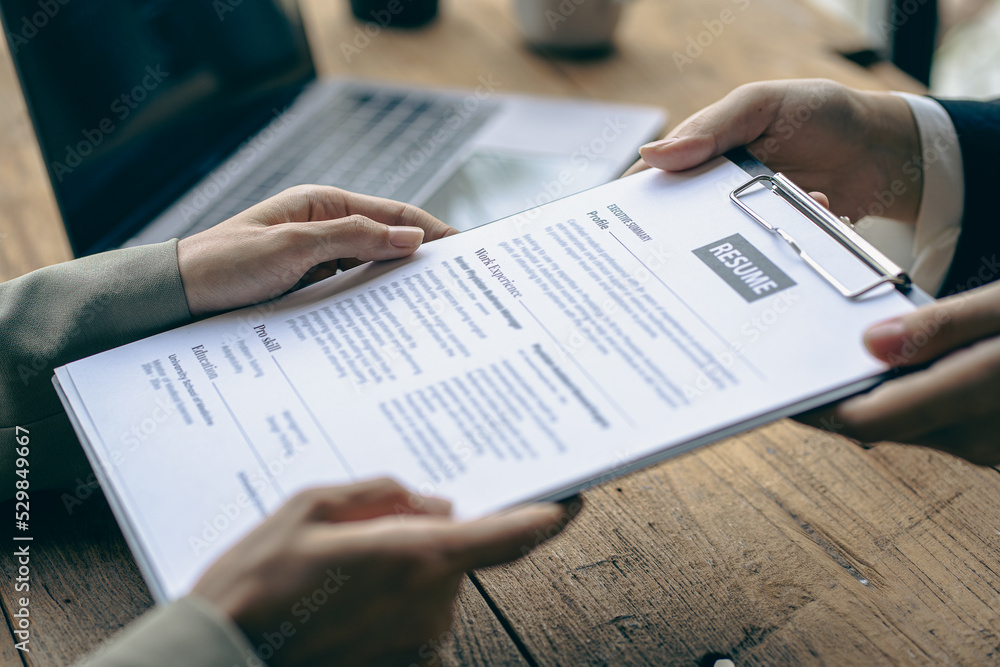 Friendly HR managers lead job interviews and read resumes with one of the candidates at the office desk. Friendly HR managers lead job interviews and read resumes with one of the candidates at the office desk.