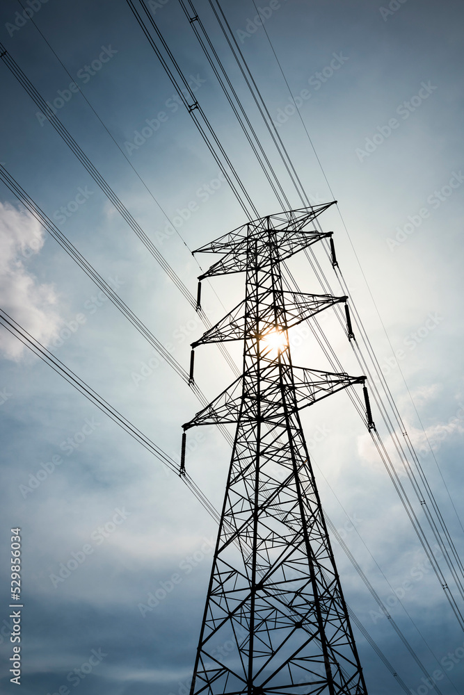 Silhouette of high voltage tower and electric line with the sky background.