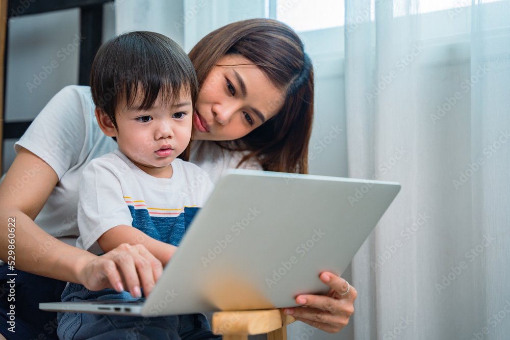 Mother she was opening something on her computer for her lovely little son to watching. Mother she was opening something on her computer for her lovely little son to watching.