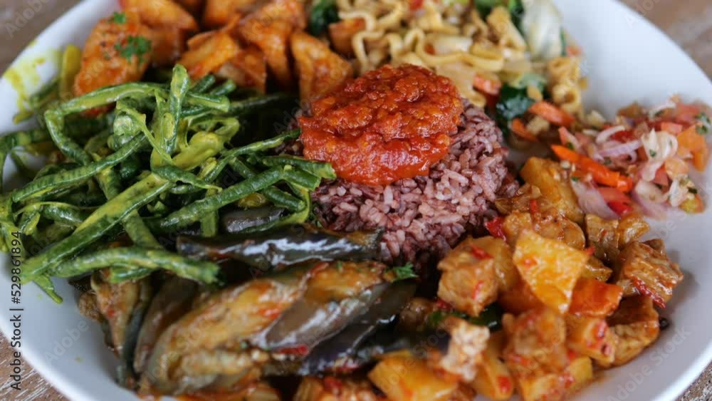 Indonesian traditional vegetable meal with rice, chilli sauce and noodles, a dish with vegetables fried in vegetable oil without animal protein for proper nutrition and maintenance of health. Indonesian traditional vegetable meal with rice, chilli sauce and noodles, a dish with vegetables fried in vegetable oil without animal protein for proper nutrition and maintenance of health.