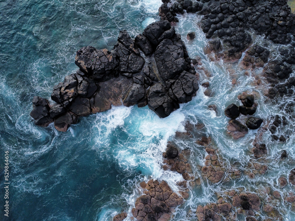 Obraz premium Drone shot of waves crashing on rocks in Mauritius