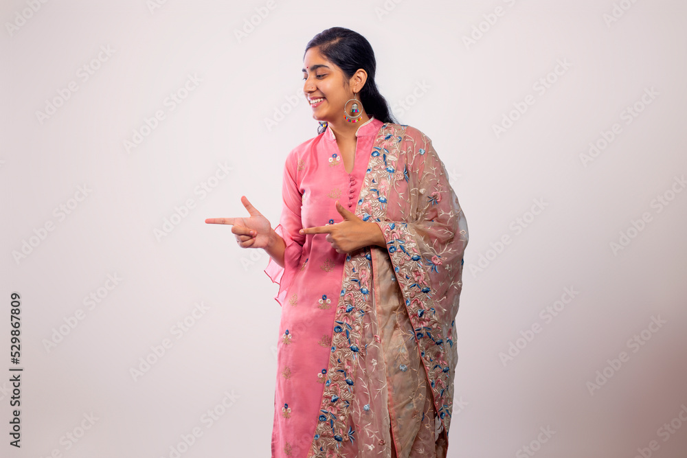 young Teenager girl smiling and pointing sideways young Teenager girl smiling and pointing sideways