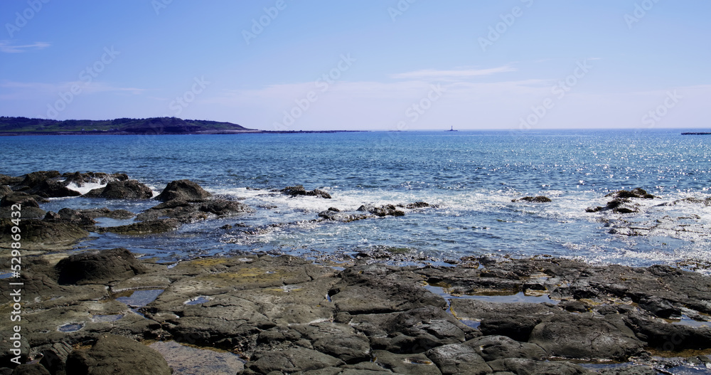 Sea over the rock beach in sunny day