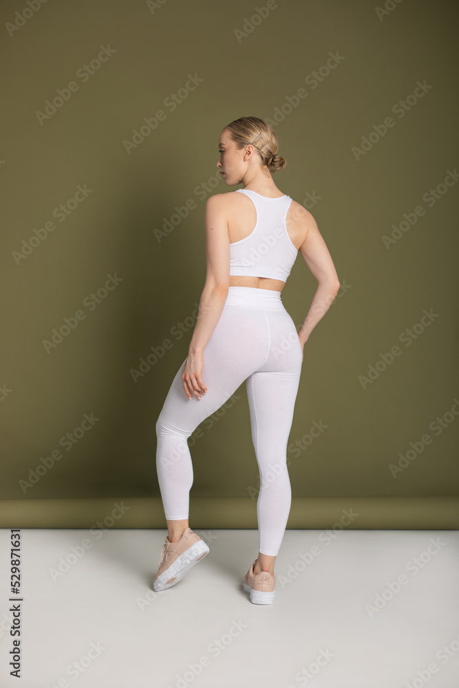 Young woman in a white sports top and leggings. Mock-up. Young woman in a white sports top and leggings. Mock-up.