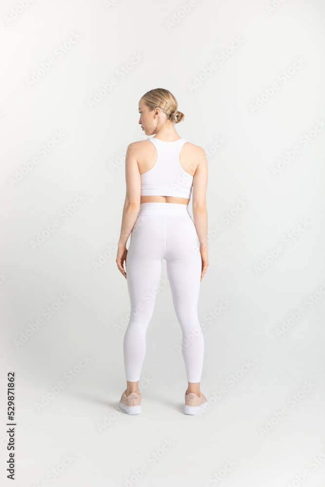 Naklejka premium Young woman in a white sports top and leggings. Mock-up.