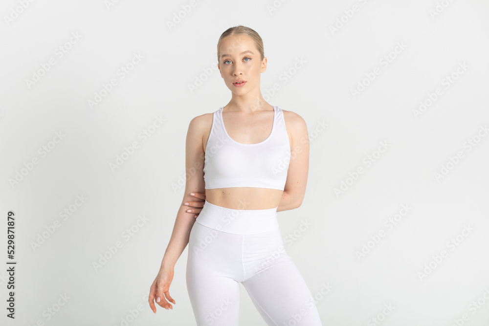 Young woman in a white sports top and leggings. Mock-up. Young woman in a white sports top and leggings. Mock-up.