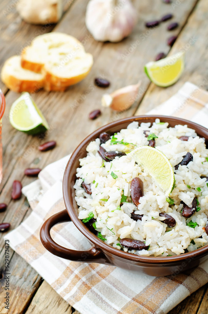 Coconut lime rice with red beans and cilantro in a bowl on a wood background Coconut lime rice with red beans and cilantro in a bowl on a wood background