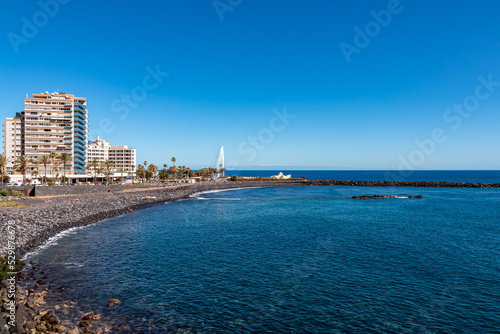 Hotel with scenic view on the beach Playa de Martianez in tourist town Puerto de la Cruz, Tenerife, Canary Islands, Spain, Europe. Big water fountain can be seen from the water park Lago Martianez.