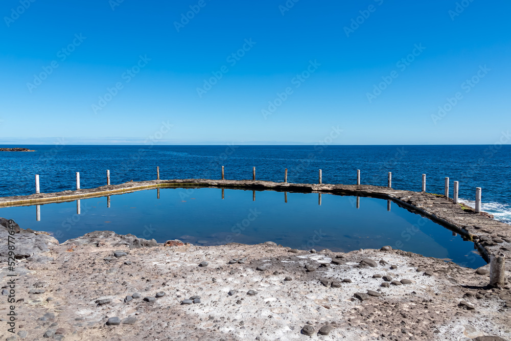 Panoramic view on the Ocean Pool Piscina Natural de Laja de la Sal near the tourist town Puerto de la Cruz, Tenerife, Canary Islands, Spain, Europe. Beautiful reflections on the water surface Panoramic view on the Ocean Pool Piscina Natural de Laja de la Sal near the tourist town Puerto de la Cruz, Tenerife, Canary Islands, Spain, Europe. Beautiful reflections on the water surface