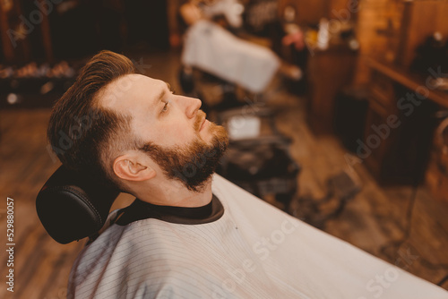 Barbershop concept, vintage color. Portrait happy client man in chair, top view
