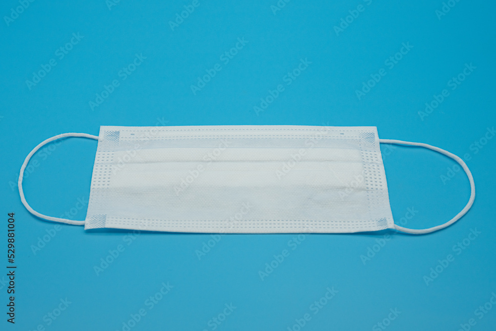 Disposable protective masks of various colors on a blue background Disposable protective masks of various colors on a blue background