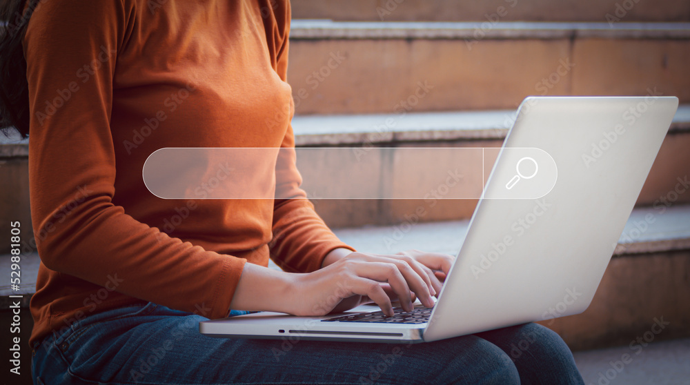 Naklejka premium Hand of young woman working with laptop computer, Searching Browsing Internet Data Information with blank search bar. Search Engine Optimization SEO Networking Concept.