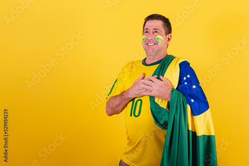 adult man, soccer fan from Brazil, wearing the flag, singing the national anthem photo