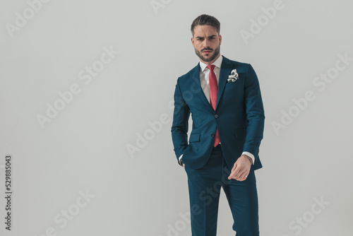 Photo cool bearded guy wearing elegant suit and holding hand in pocket