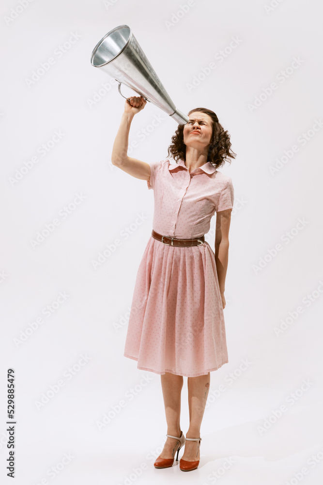 Portrait of young emotive woman looking in tube isolated over white studio background. Information search Portrait of young emotive woman looking in tube isolated over white studio background. Information search