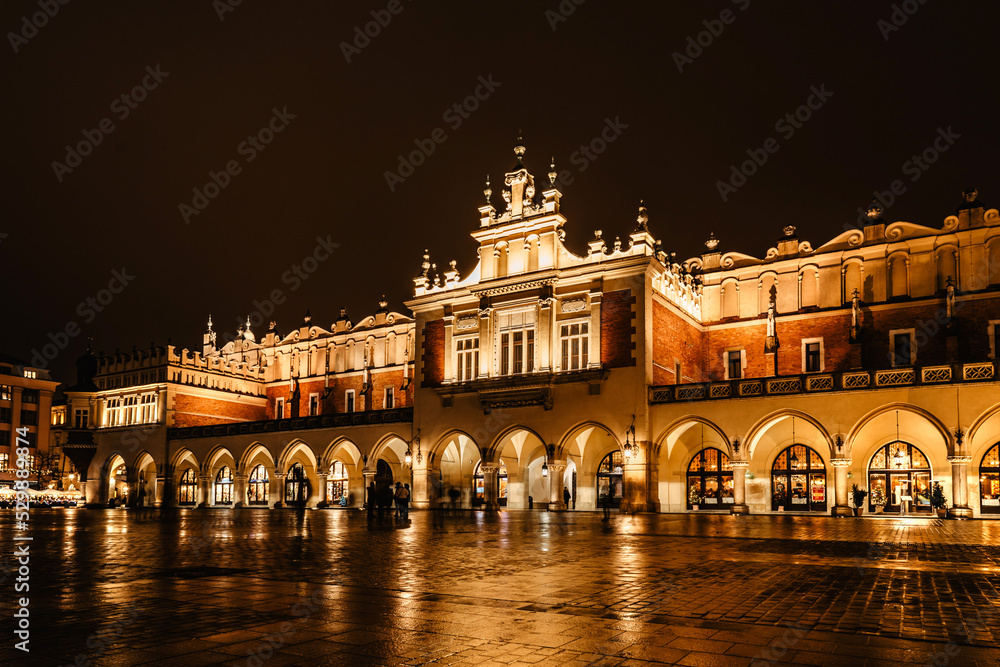 Obraz premium Illuminated Krakow Cloth Hall, Polish Sukiennice on main market square,Poland.Renaissance building at night during Christas.Evening city lights.Festive atmosphere.Historic center of Krakow.UNESCO site