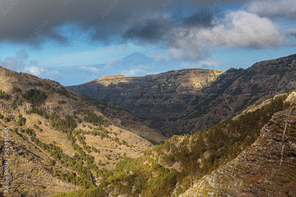 Wild mountain landscape on the isle of La Gomera with the volcano 'El Teide' on the isle of Tenerife in the background, Spain