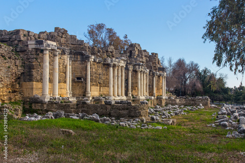 View of the ruins of the monumental ancient Roman fountain Nymphaeum with snow-white marble columns in the historic part of Antique Side, near Antalya, Turkey