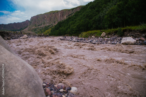 Muddy river water. Spring flood. Dirty muddy water with a whirlpool and white foam close-up.A mountain river or stream raging during a flash flood.