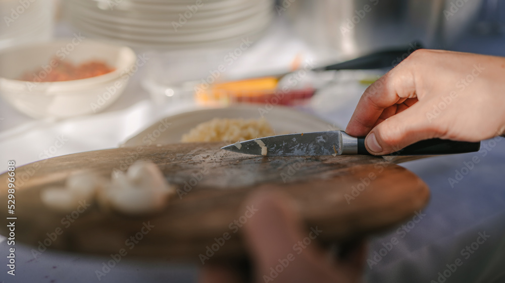 Close up photo of male hands is preparing wonderful fresh salad. Chef cooking food cutting prepare hands knife preparing vegetables.