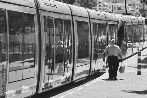 man walking to a train with his back to the camera, black and white 