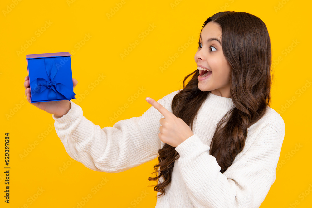 Excited teenager girl. Funny kid girl in winter wear holding gift boxes celebrating happy New Year or Christmas. Winter holiday. Excited teenager girl. Funny kid girl in winter wear holding gift boxes celebrating happy New Year or Christmas. Winter holiday.