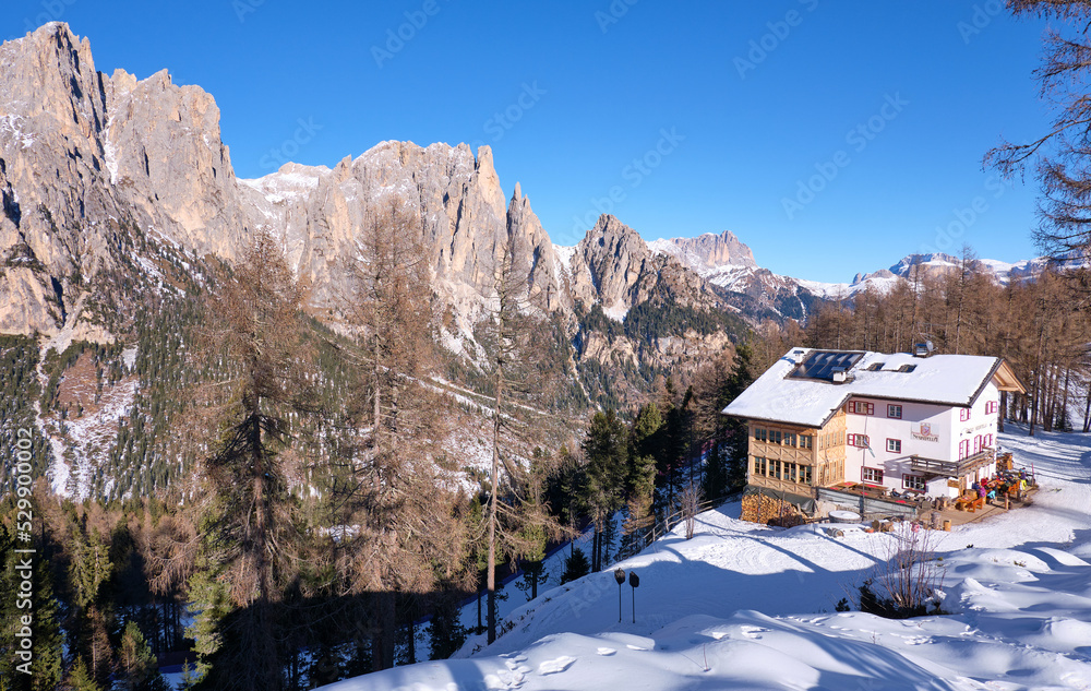 chalet in the mountains in val di fassa in winter, with snow