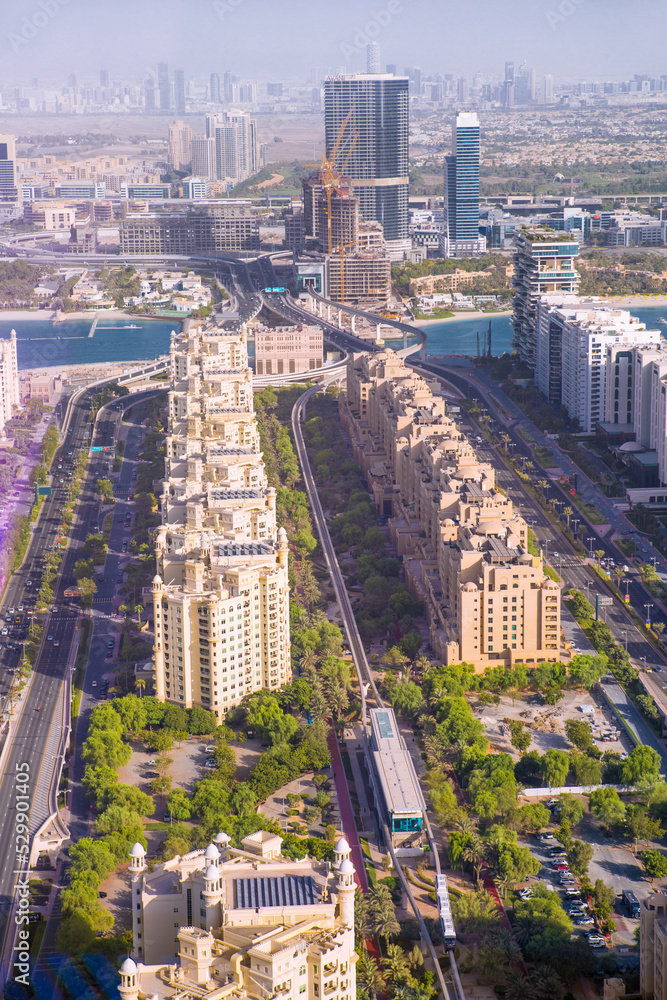 The Palm Jumeirah road with monorail, parks and Hotels view at sunset. Dubai, UAE