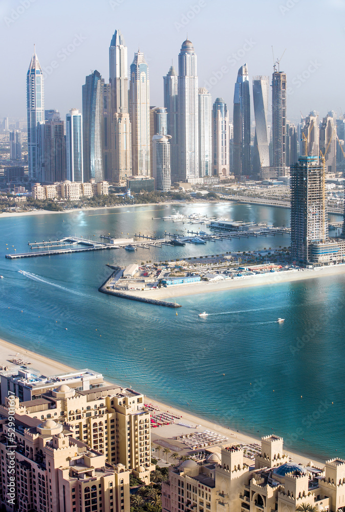 Fototapeta premium Dubai, UAE. Dubai Marina yachts pier view at sunset with beautiful golden reflection in the water