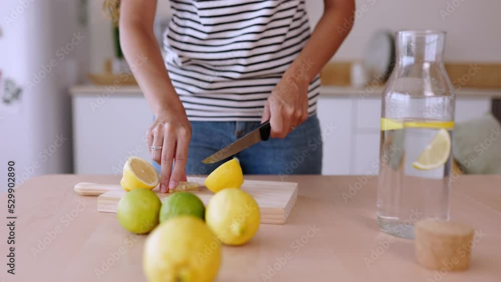Close up woman hands cutting lemons to prepare homemade lemonade juice in the kitchen at home Close up woman hands cutting lemons to prepare homemade lemonade juice in the kitchen at home