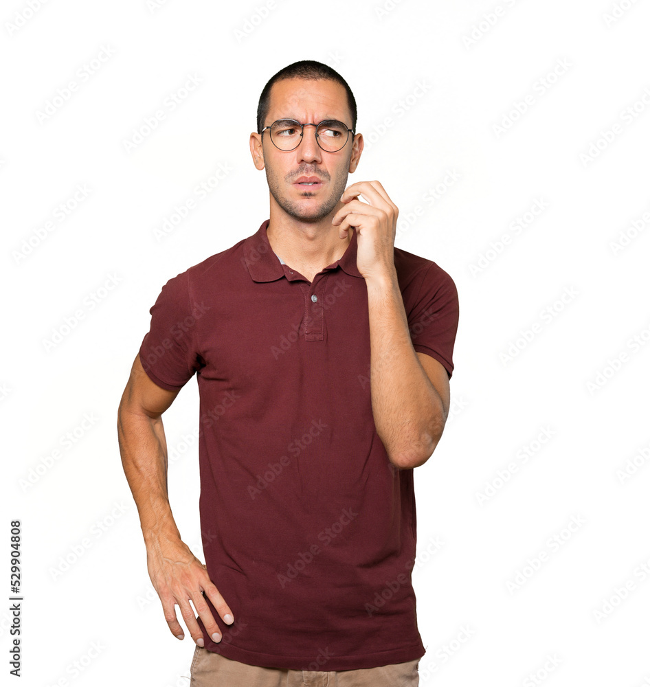 Concerned young man making a gesture of doubt Concerned young man making a gesture of doubt