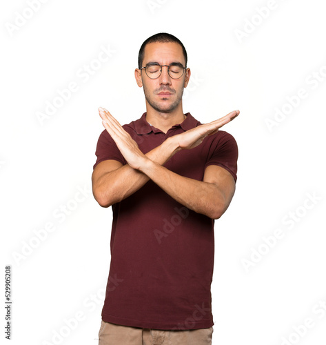 Young man making a gesture of not crossing with the arms photo