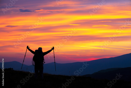 Hiker woman with raised arms on the mountain top
