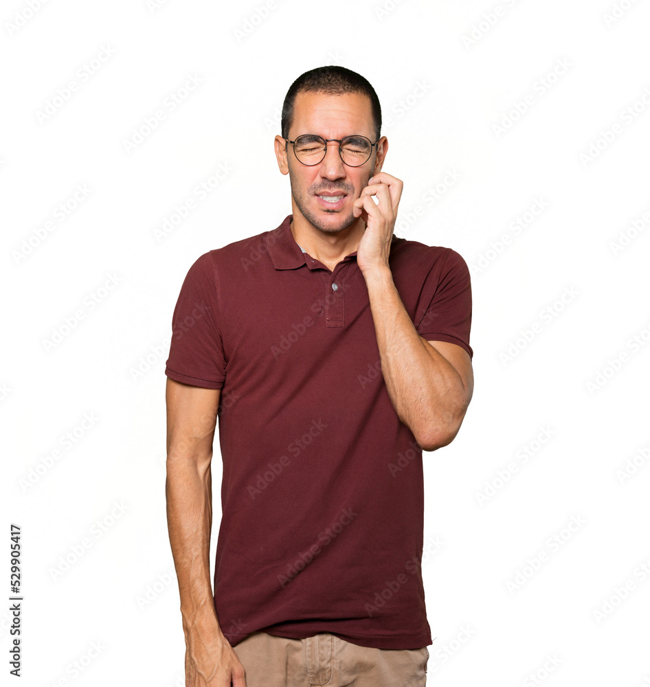 Concerned young man making a scratching gesture Concerned young man making a scratching gesture