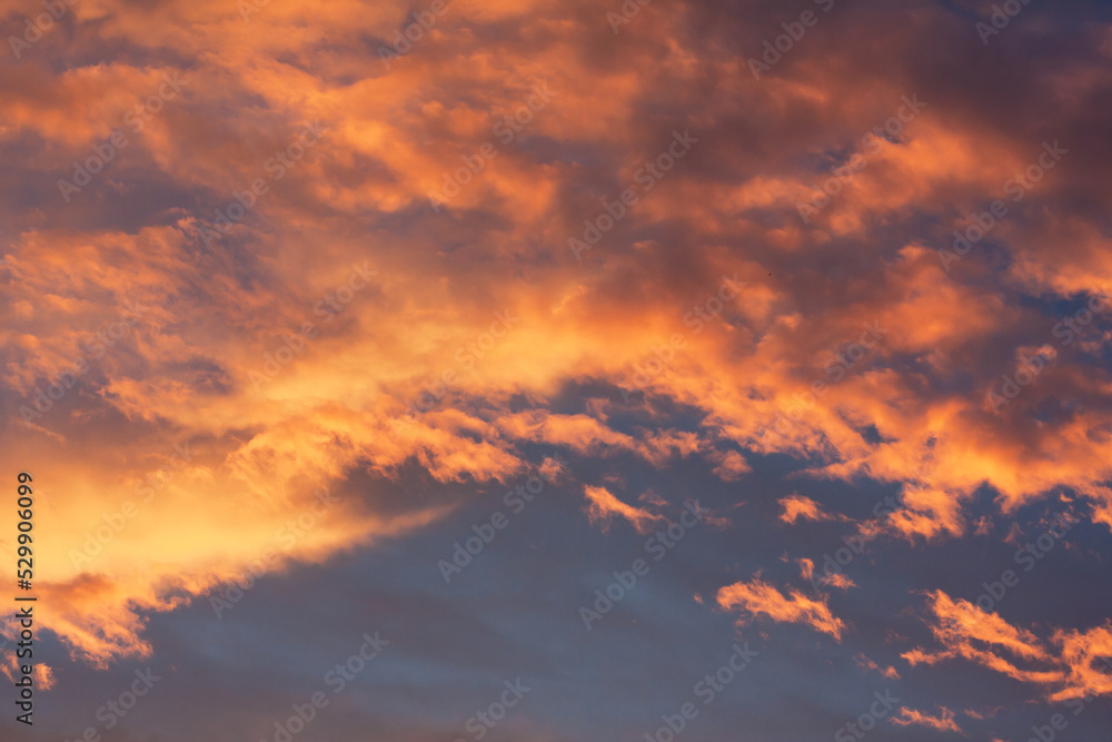 Beautiful sunset sky. Colorful clouds in blue sky are colored by light of setting or rising sun. Summer evening. Abstract natural background. sky texture