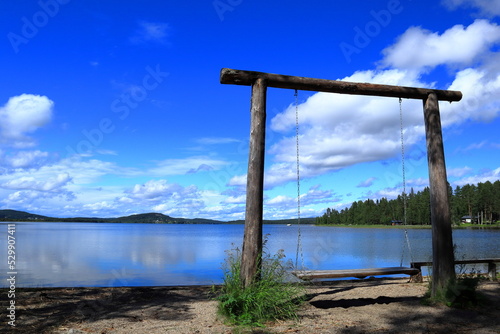 Large wooden swing by a lake. Nice calm Swedish nature and seascape view. Summer of 2022. Krokom, Jämtland, Sverige. © Martin of Sweden
